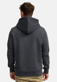 Donkere grijze hoodie met een grote, puntige capuchon, geribbelde manchetten en een zoom. Gemaakt van een gestructureerde stof, met een minimalistisch ontwerp.