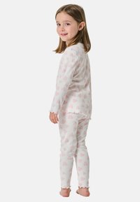 Pyjama-Set mit gerippter Textur, weiß mit rosa Herzmustern, langen Ärmeln und Rüschensaum an den Bündchen und dem Saum.