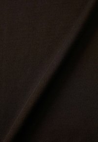 Mörkbrunt stickat tyg som visar en slät textur med fin ribbning och en lätt glans, elegant draperat över sig själv.