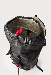 Must kaasimitähega seljakott, mis on valmistatud veekindlast materjalist, punaste detailidega, reguleeritavate rihmadega ja avara beežist voodriga sisemusega.