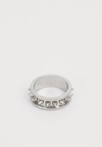 Silberner Metallring mit gleichmäßig verteilten konischen Spitzen rund um den Ring, auf einem schlichten weißen Hintergrund dargestellt.