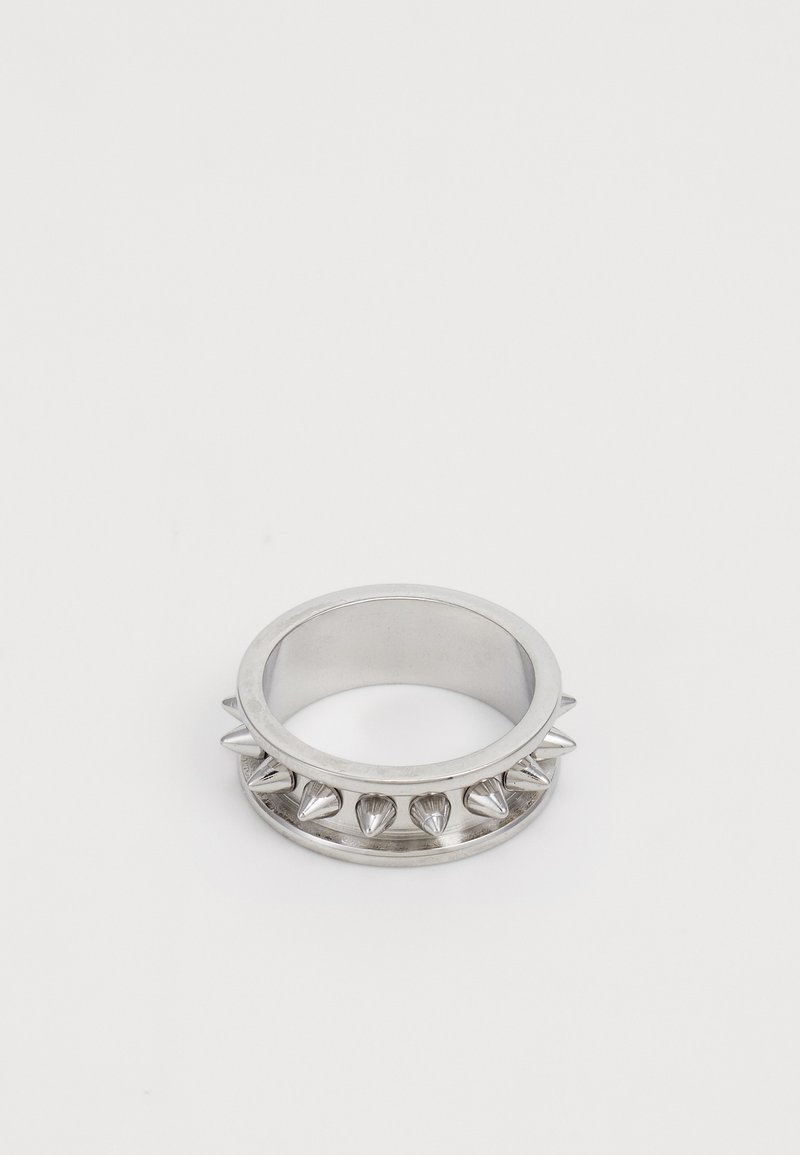 Silberner Metallring mit gleichmäßig verteilten konischen Spitzen rund um den Ring, auf einem schlichten weißen Hintergrund dargestellt.