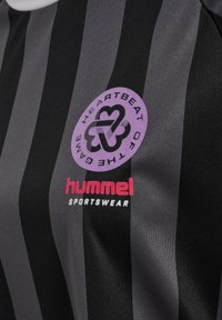 Svart och grårandig sporttröja med en lila logotyp och texten "HEARTBEAT OF THE GAME" samt röd "hummel SPORTSWEAR"-branding.
