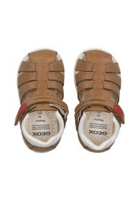 Hnědé kožené sandály s bílými podrážkami, s uzavřenou špičkou, několika popruhy a červeným akcentem na nastavitelném popruhu. Velikost 20.