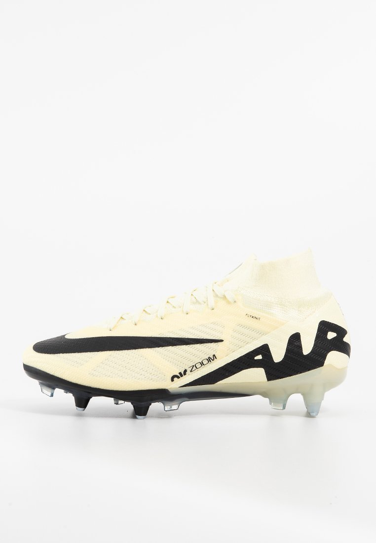 Crampons de football jaune clair avec des accents noirs, tige texturée et col en forme de chaussette. Comprend des crampons pour une traction sur des surfaces en herbe.