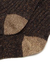 Chaussettes brunes côtelées avec des accents texturés marron et beige aux poignets. Matériau doux et tricoté avec un aspect confortable.