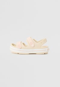 Chanclas de goma beige con dos correas ajustables en rosa claro, que presentan una suela con agarre estampada y una banda de acento blanca.