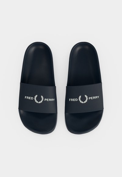 Черни сандали с платформа и широка каишка, с бял текст "Fred Perry" и ловоров венец на всяка каишка.