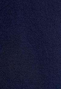 Námořnická modrá texturovaná látka s krabatým vzhledem, vyrobená z měkkého textilního materiálu, vykazující jemné tonální variace.