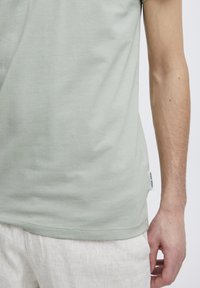 Lys grøn bomulls t-skjorte med rund hals, korte ermer og et sidelabel. Myk tekstur og enkelt design.