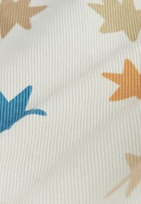 Stoff mit weißem Hintergrund und Sternmustern in Blau, Beige und Orange. Die Textur ist gerippt und fühlt sich weich an.