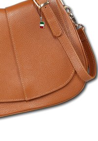 Tan leather handbag with a textured finish, curved design, gold-tone hardware, and a small Italian flag charm attached to the strap.