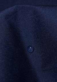 Navy blue fabric with a smooth texture, featuring a water droplet resting on the surface, indicating water resistance.
