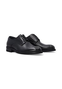 Ein Paar schwarze Lederformalschuhe mit Schnürung, runden Zehen und flachen Absätzen auf einem weißen Hintergrund.