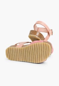 Two-tone pink sandals with a textured brown cork footbed, adjustable ankle strap, and ridged, flexible rubber outsole.
