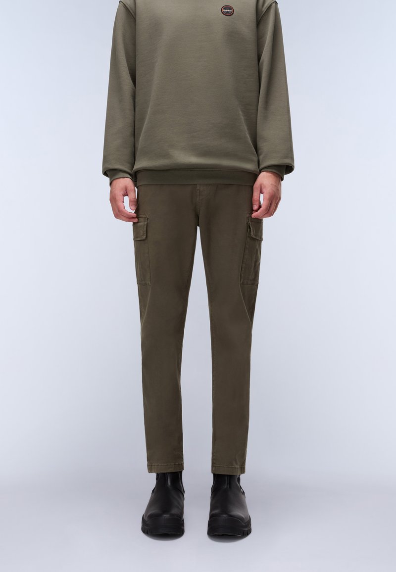 Olivgrüner Sweatshirt mit Rundhalsausschnitt; passende Cargo-Shorts mit Seitentaschen; kombiniert mit schwarzen Knöchelstiefeln; glatte Textur, moderner Schnitt.
