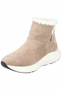 Bottine en daim beige avec un col en fausse fourrure blanche, bout rond et semelle blanche rembourrée ; présente des coutures latérales et une étiquette de logo.