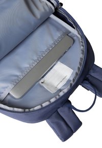 Mørkeblå ryggsekk med lys tekstilfôr, utstyrt med polstret laptop-lomme, hengelapp og to skulderstropper.