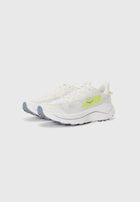 Weiße Sportschuhe mit einem Mesh-Obermaterial, reflektierenden Akzenten und einem HOKA-Logo. Dicke gepolsterte Sohle mit grauen und gelben Details.