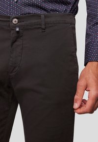 Zwarte katoenen broeken met een vlakke voorkant, zijzakken en knoopsluiting. Kenmerken een gestructureerde afwerking en zichtbare stiksel details.