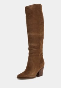 Bottine en suede marron à hauteur de genoux avec un bout pointu et un talon en bois empilé. Présente une texture lisse et des détails de couture minimalistes.