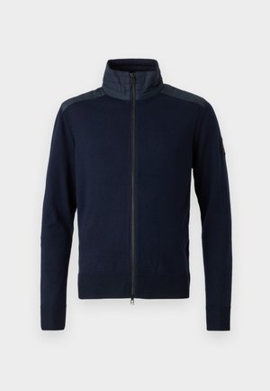 Casaco de zíper azul-marinho com colarinho alto, punhos elásticos e detalhes texturizados nos ombros. Feito de um tecido tricotado com acabamentos lisos.