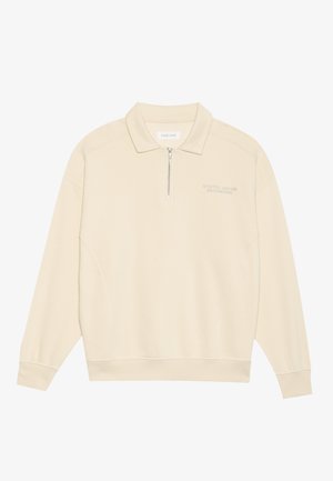 Pull beige avec un col zippé, fabriqué en tissu doux. Présente des poignets côtelés et un subtil détail brodé sur la poitrine. Design à coupe droite.