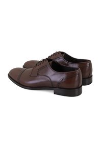 Een paar gepolijste bruine leren herenschoenen met veters en decoratieve perforaties, zij aan zij weergegeven op een witte achtergrond.