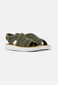 Olive green sandals with a mesh upper and cross-strap design. Features a white, textured rubber sole and cork insole for comfort.
