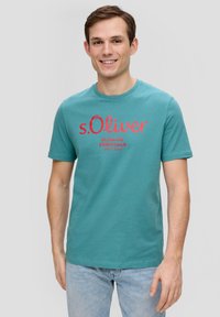 Turkooise katoenen t-shirt met korte mouwen, voorzien van rode bedrukte tekst "s.Oliver ELEVATED ESSENTIALS," ronde ronde hals en een regular fit.