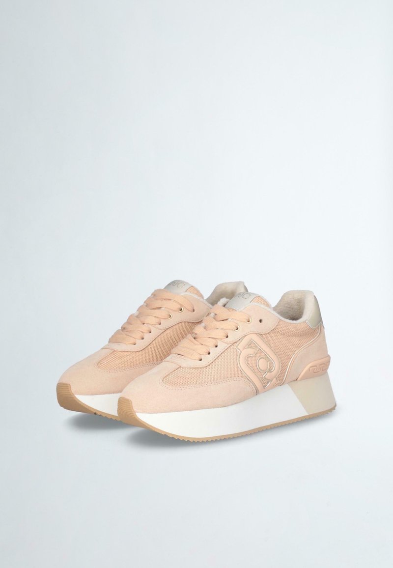 Sneakers z jasnoróżową zamszową cholewką, siateczkowymi akcentami, białą podeszwą środkową i teksturowaną gumową podeszwą zewnętrzną. Wyraźny detal logo po bokach.