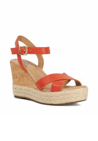 Orange wedge sandal with crossed straps, cork-textured heel, and braided rope detail. Smooth leather upper and adjustable ankle strap.