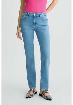 Jeans in denim blu chiaro con gamba dritta, vita alta e tasche frontali. Il modello indossa ballerine a fantasia bianco e nero.
