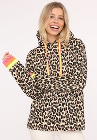 Leopard print hoodie featuring a beige background, black and brown spots, neon drawstrings, and colorful striped cuffs.