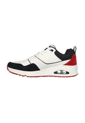Sneaker blanc avec accents noirs et rouges, présentant une tige en cuir lisse, une coque de tête en daim, un design perforé et un amorti à air visible.