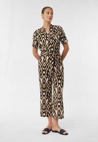 Wydrukowany kombinezon z krótkimi rękawami, z paskiem do wiązania w talii, w odcieniach brązu, czerni i kremu z abstrakcyjnym wzorem.