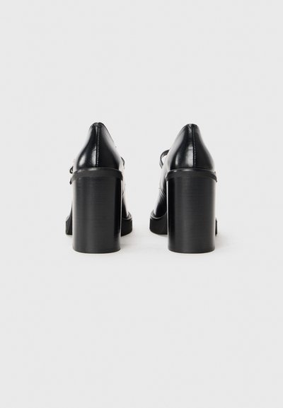 Pantofi cu toc înalt din piele neagră, cu toc robust și bot ascuțit, având un design elegant și hardware minim pe spate.