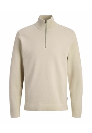 Suéter beige de punto de manga larga con cuello alto y cierre de media cremallera en la parte delantera.