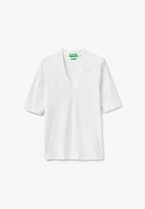 Biała koszulka z krótkim rękawem i dekoltem w serek, o lekko luźnym kroju, z zielonymi metkami marki na wewnętrznej stronie kołnierzyka z tyłu.