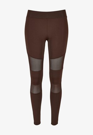 Barna leggings sima, rugalmas anyagból, áttetsző hálós panelek a combokon, és magas derék kialakítással.