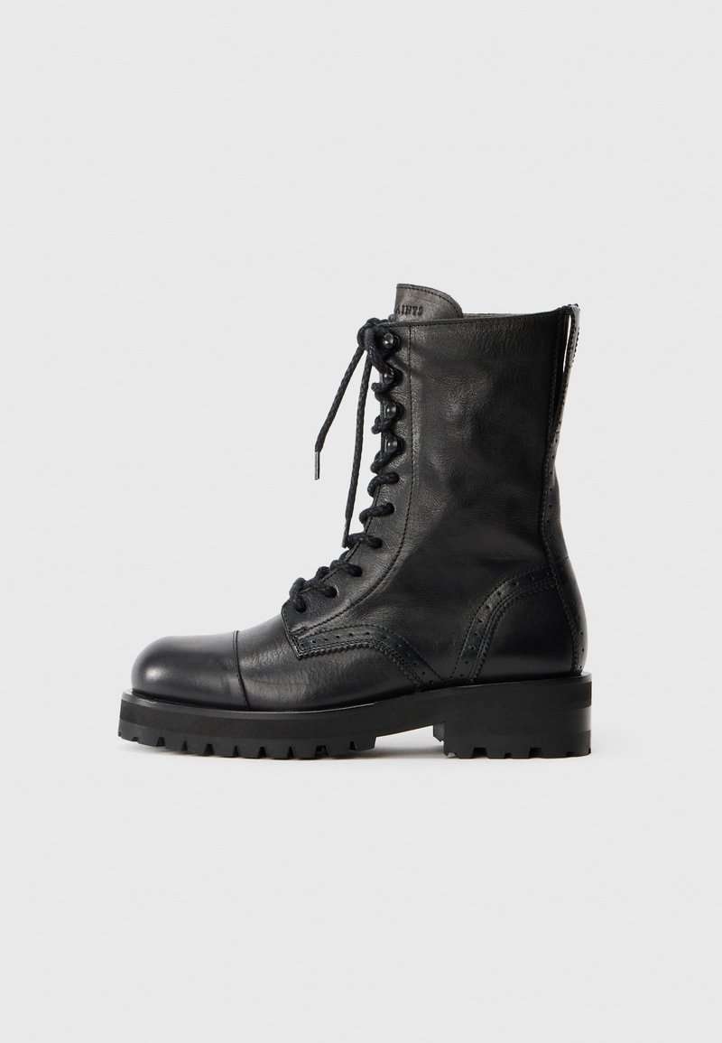 Stivali neri in pelle con lacci, dalla punta arrotondata, con dettagli brogue e suola in gomma resistente. Presentano una zip sul retro per una facile vestibilità.