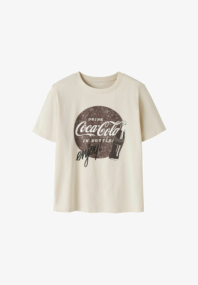 T-shirt beige à manches courtes avec logo vintage Coca-Cola, une illustration de bouteille et le texte "Drink Coca-Cola in bottle enjoy!"