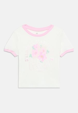 Wit kinderpolo met korte mouwen, roze biezen, bloemenafbeelding en lichtroze GAP-logo met de tekst "Western Classic" en "1994."