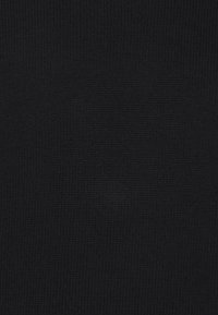 Tissu en tricot noir avec une texture fine, des points régulièrement espacés et une finition lisse, adapté aux vêtements ou aux accessoires.