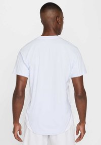 Camiseta azul claro hecha de algodón. Manga corta, cuello redondo y dobladillo curvado en la parte posterior. Textura suave con un detalle mínimo.