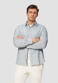 Lichtblauw gestreepte button-up shirt met een klassieke kraag, lange mouwen en witte knopen, gedragen over een wit onderhemd. Gestructureerde stof.