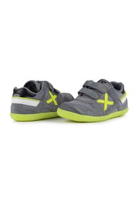 Scarpe in suede grigio con suole in gomma verde, dotate di cinturini in Velcro e accenti gialli. Design ergonomico con superficie superiore testurizzata.