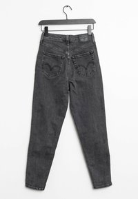 Musta farkkutyyli skinny-farkut, joissa on takataskut kaarevalla ompelusuunnitelmalla. Tavanomainen vyötärö ja helma, minimoitu haalistuminen.