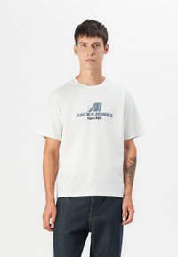Lichtgrijze katoenen T-shirt met een blauwe grafische print van "JACK & JONES core dept." op de borst en korte mouwen.