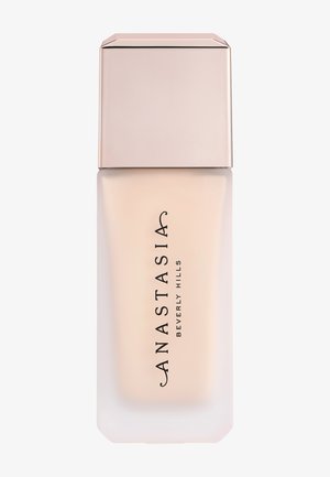 Rechthoekige matglazen fles met lichtbeige vloeibare foundation en lichtbeige vierkante dop, gelabeld "Anastasia Beverly Hills."